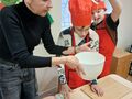 Łukasz wlewa śmietanę do miski