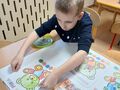 Eryk przykleja kartkę z misiem