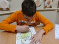 Kacper koloruje kredkami misia