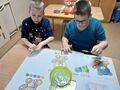 Wiktor smaruje klejem kartkę