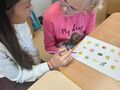 uczennica siedzi przy ławce w klasie i pracuje z psychologiem
