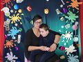 11 na zdjęciu mama z synem siedzą na tle scianki z napisem akademia Pana kleksa