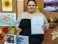 1.uczennica pozuje do zdjęcia z dyplomem i nagrodą