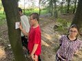 Uczniowie w parku szukają kartek z zadaniem