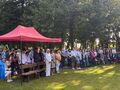 uczniowie nauczyciele i rodzice stoją i uczestniczą we mszy św 