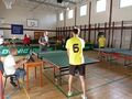 Dominik i przeciwnik w trakcie odbija piłki w momencie gry w tenisa stołowego. 