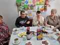 uczeń z mamą i swoim gośćmi siedzi przy urodzinowym stole