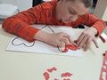2. Wychowanek wykonuje pracę plastyczną serce 