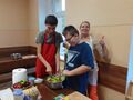 Dzieci z panią mieszają kolorową salatkę