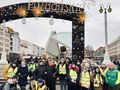 uczniowie i nauczyciele pozują do zdjęcia przy wejściu na Betlejem Poznańskie Jarmark Świąteczny