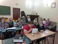 Uczennice siedzą przy ławkach w klasie i biorą udział w ćwiczeniu aktywizującym