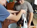 dwóch chłopców wkłada do sokowirówki jabłka i marchewki