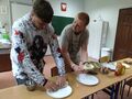 dwóch uczniów nad talerzami zawija w naleśnik sałatkę
