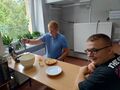 uczeń nakłada ciasto do gofrownicy drugi z uczniow siedzi obok
