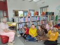 uczniowie słuchają bajki czytanej przez panią bibliotekarke