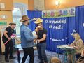 uczniowie i nauczyciel występują trzymają w rękach rekwizyt konia na kiju