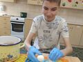 uczeń obiera jajko przy stole