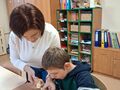 uczeń razem z nauczycielem robią szszłyka z owocó