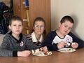 uczniowie prezentują swoje szszłyki z owoców