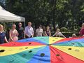 dorosli i dzieci trzymają chuste klanzy w parku na placu zabaw