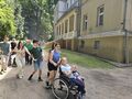 uczestnicy idą jeden za drugim za nimi szkoła z przodu dziewczynka na wózku