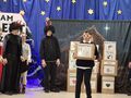 5.uczniowie występują w jasełkach stoją na scenie jeden trzyma karton z napisem lenistwo