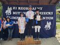zdjęcie zawodników na podium trzymają dyplomy