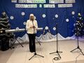 1.pani dyrektor wita przybyłych gości i uczestników stoi na scenie na sali w Konarzewie w tle napis XVII Międzyszkolny Konkurs Kolęd Pastora