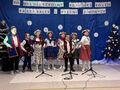 3.uczestnicy konkursu wykonują utwór na scenie w tle napis XVII Międzyszkolny Konkurs Kolęd Pastorałek i Pieśni Zimowych