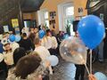 uczniowie biorą udział w zabawie z balonami w holu ośrodka