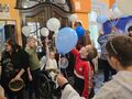 uczniowie podczas zabawy w holu ręce i balony uniesione ku górze