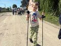 Uczeń dzielnie maszeruję z kijkami. 