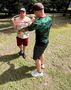 uczen przeklada hula hop przez ciało z pomoca nauczyciela