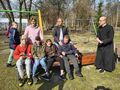 dzieci oglądają część artystyczną na ławce na boisku