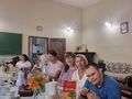nauczycielki uczniowie oraz rodzice siedzą przy zastawionym stole