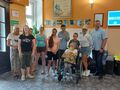 Pani Dyrektor dzieci i goscie stoją w holu ustawieni do zdjęcia grupowego