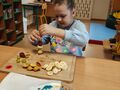 dziewczynka nakłada kawałki owoców na saszłyk
