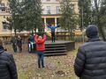 Nauczyciel pokazuje ćwiczenia uspakajające z kijkami. 
