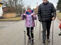 Uczennica i uczeń wspólnie maszerują w trakcie spaceru nordic walking. 