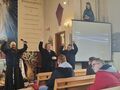 12. uczniowie razem z o. Walentym na rekolekcjach w kościele ilustrują gestami piosenkę rekolekcyjną