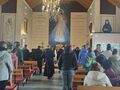 8. uczniowie razem z o. Walentym na rekolekcjach w kościelestoją w tle duży obraz Jezusa Miłosiernego