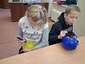 uczniowie wykonuja cwiczenia z balonami w swojej klasie