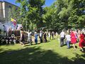wszyscy trzymają sie za ręke i jeden za drugim tańczą przed sceną