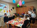 Na zdjęciu widoczni są uczniowie oraz panie. Dzieci przebywają w klasie i świetują urodziny kolegi. 
