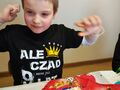 Zdjęcie przedstawia uśmiechniętego chłopca który świętuje swoje 9 urodziny. Na koszulce jest napis Ale czad mam już 9 lat. 