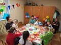 Na zdjęciu widzimy uczniów oraz panie. Wszyscy znajdują się w klasie i świętują urodziny chłopca. 