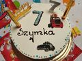 Zdjęcie przedstawia tort. Na torcie znajduje się napis 7 urodziny Szymka 