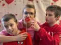 6. Uczniowie z nauczycielką pozują do zdjęcia na tle walentynkowej fotościanki