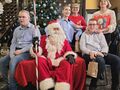 17 mikołaj siedzi na fotelu dzieci i nauczyciele z klasy obok mikołaja pozują do zdjęcia