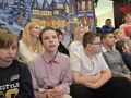 3 dzieci i nauczyciele siedzą w holu